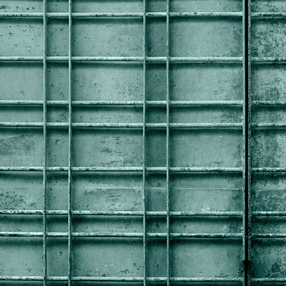             Digital behang »bangalore« - Close-up van een petrolkleurig metalen hek met rechthoekige decoraties - Gladde, licht parelmoerachtige non-woven stof
        